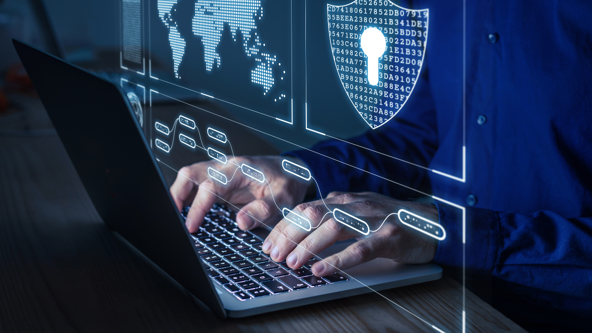 Person working at a laptop with a security sign on the screen